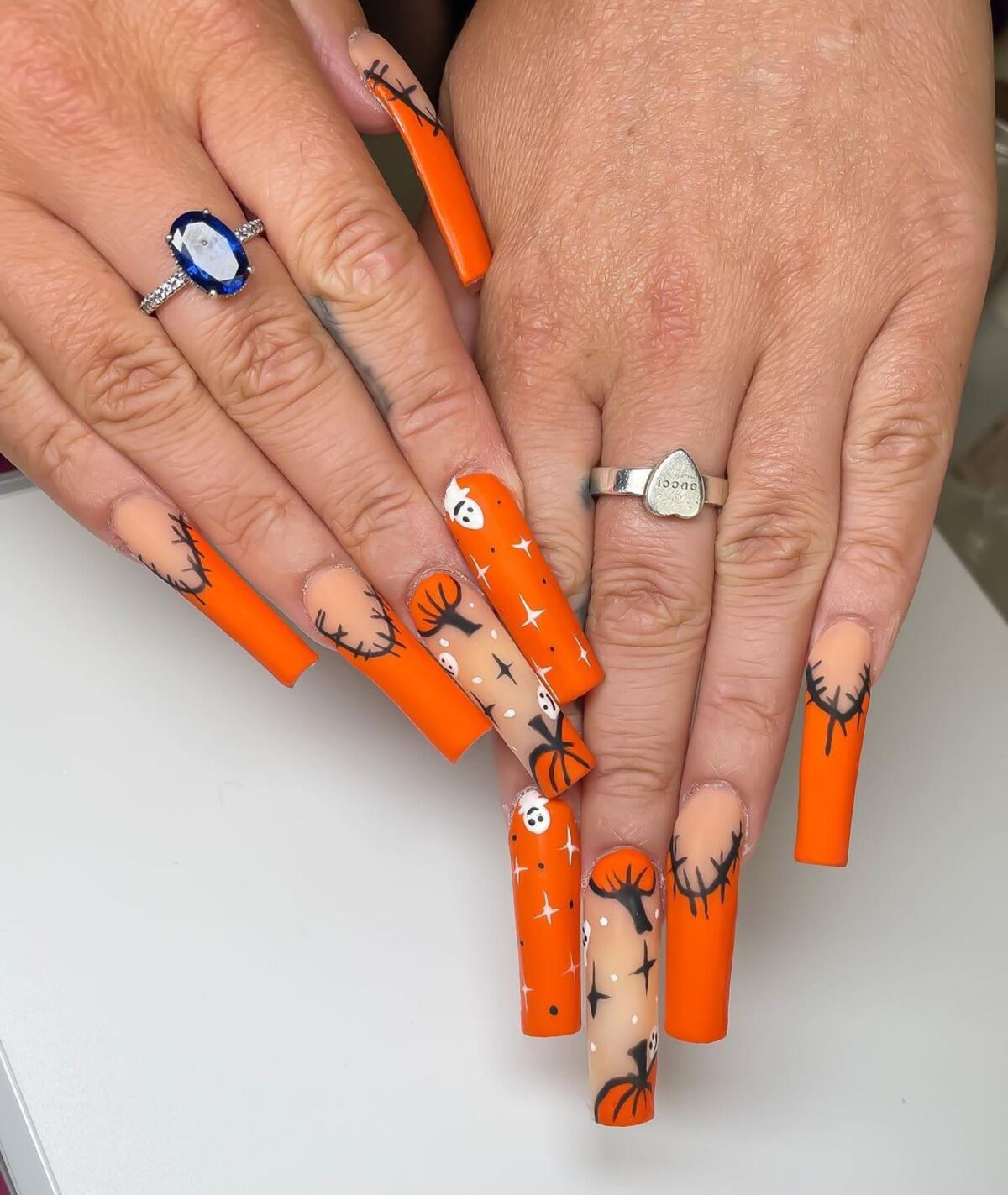 19. Bright Orange Nails with Spooky Details