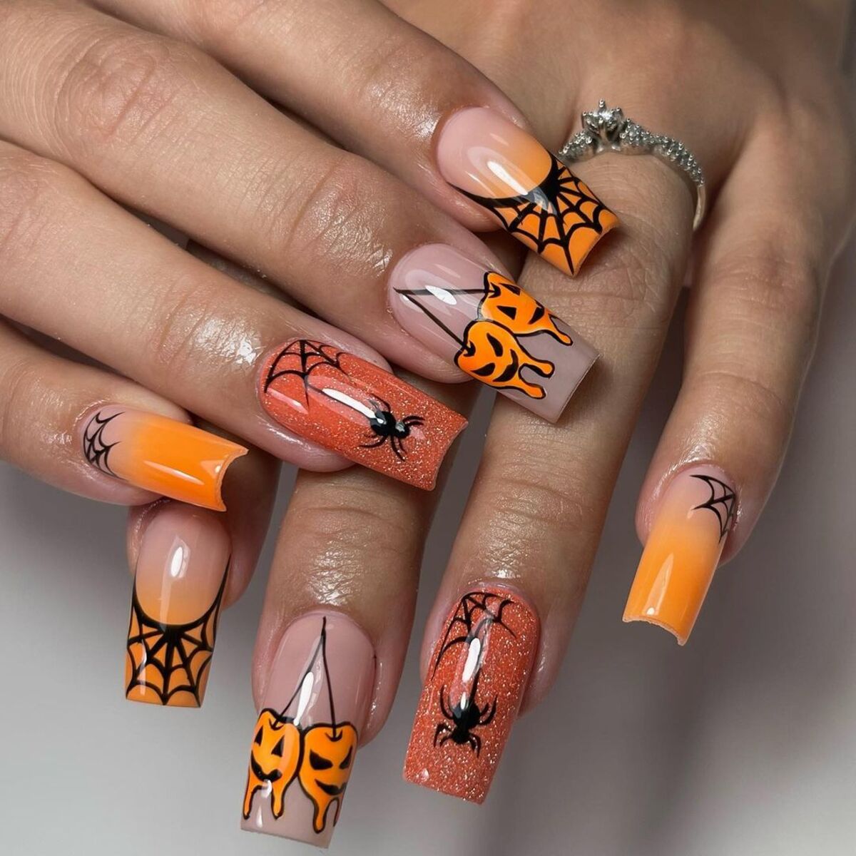 21. Bright Orange Halloween Glam with Glitter and Webs