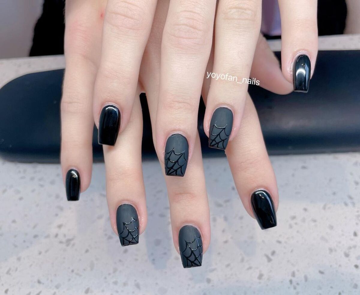 4. Glossy Black Nails with Subtle Spiderweb Patterns