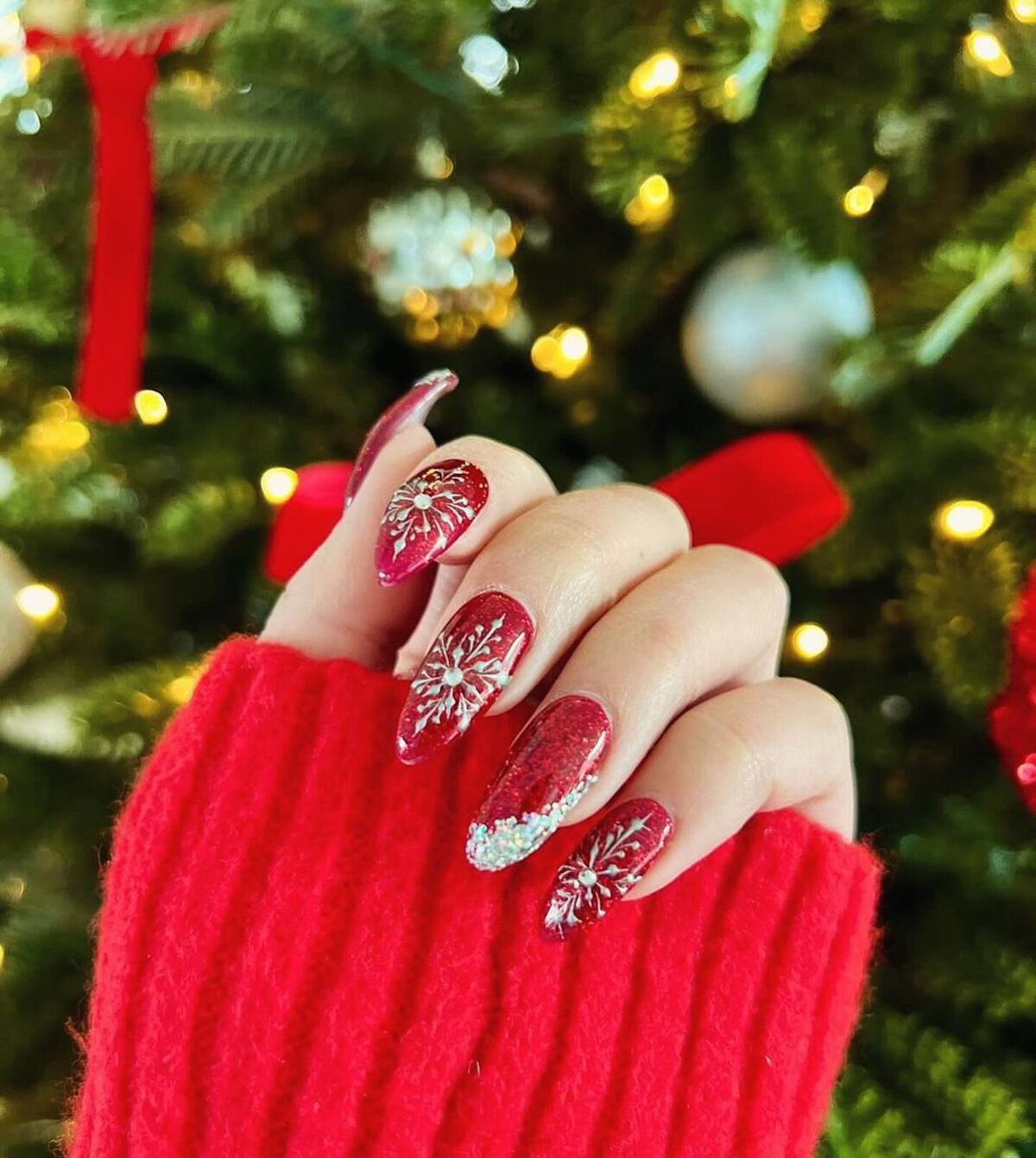 24. Festive Red Glitter and Snowflake Nails