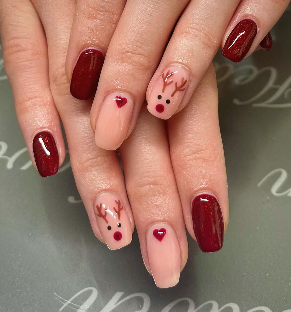 1. Festive Reindeer Accents with Deep Red Polish