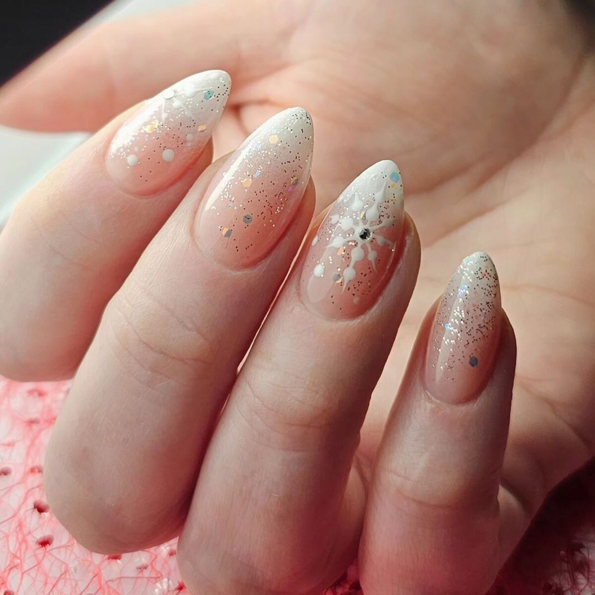 7. Glossy Almond Nails with White and Silver Snowflakes