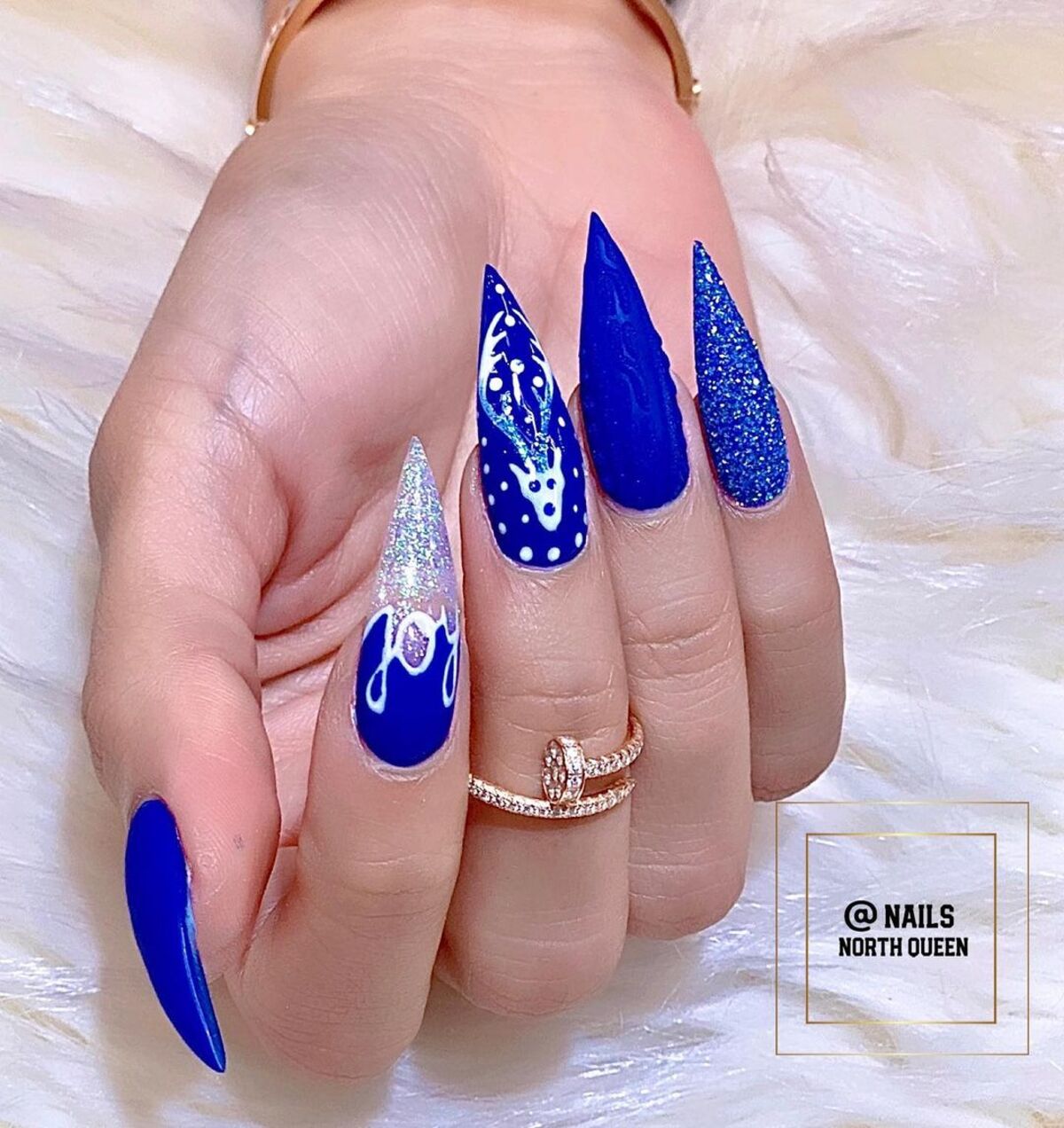 21. Royal Blue Stiletto Nails with Sparkle and Reindeer