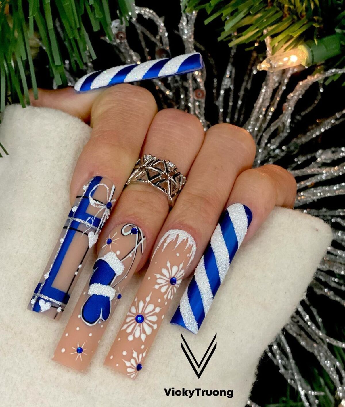 24. Blue and White Candy Cane-Inspired Nails