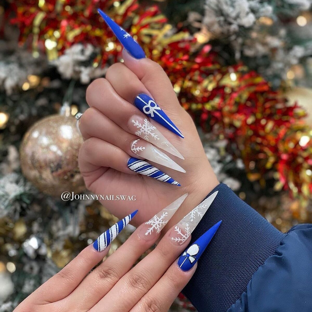 31. Frosty Blue and White Stiletto Nails with Snowflakes