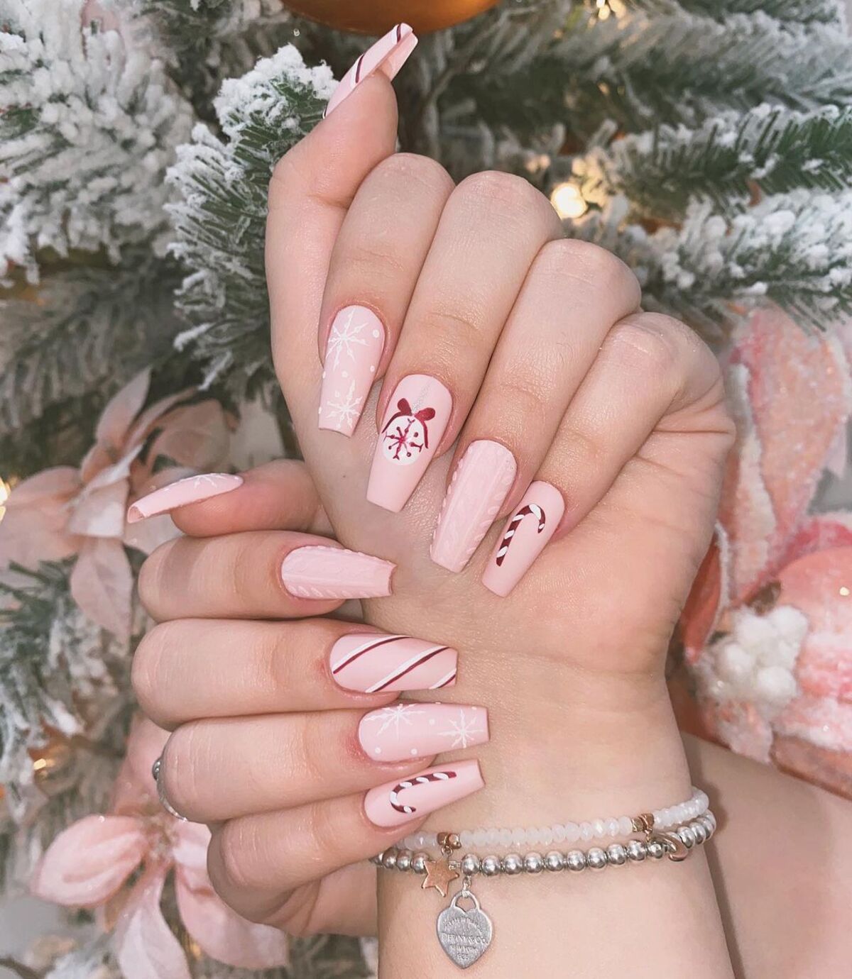 25. Peppermint Candy and Snowflake Holiday Nails