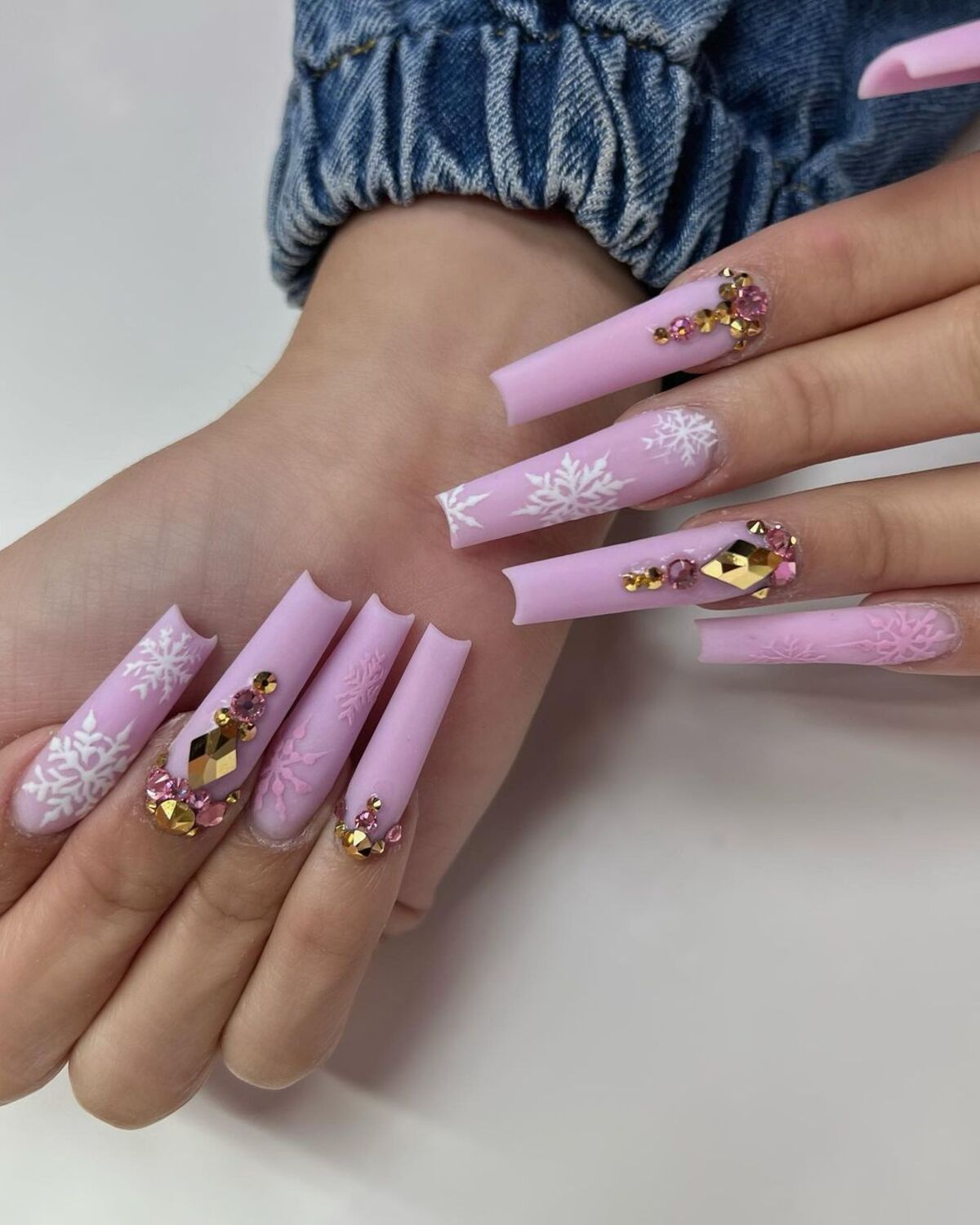 7. Luxurious Pink and Gold Snowflake Nails