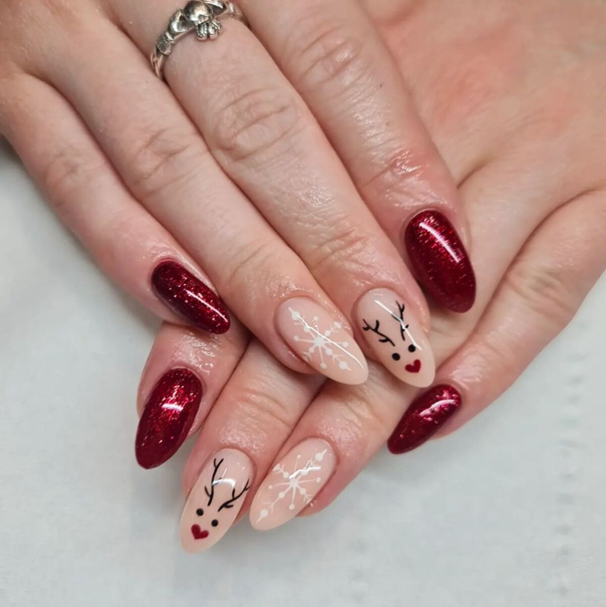 1. Festive Red Glitter and Reindeer Nails