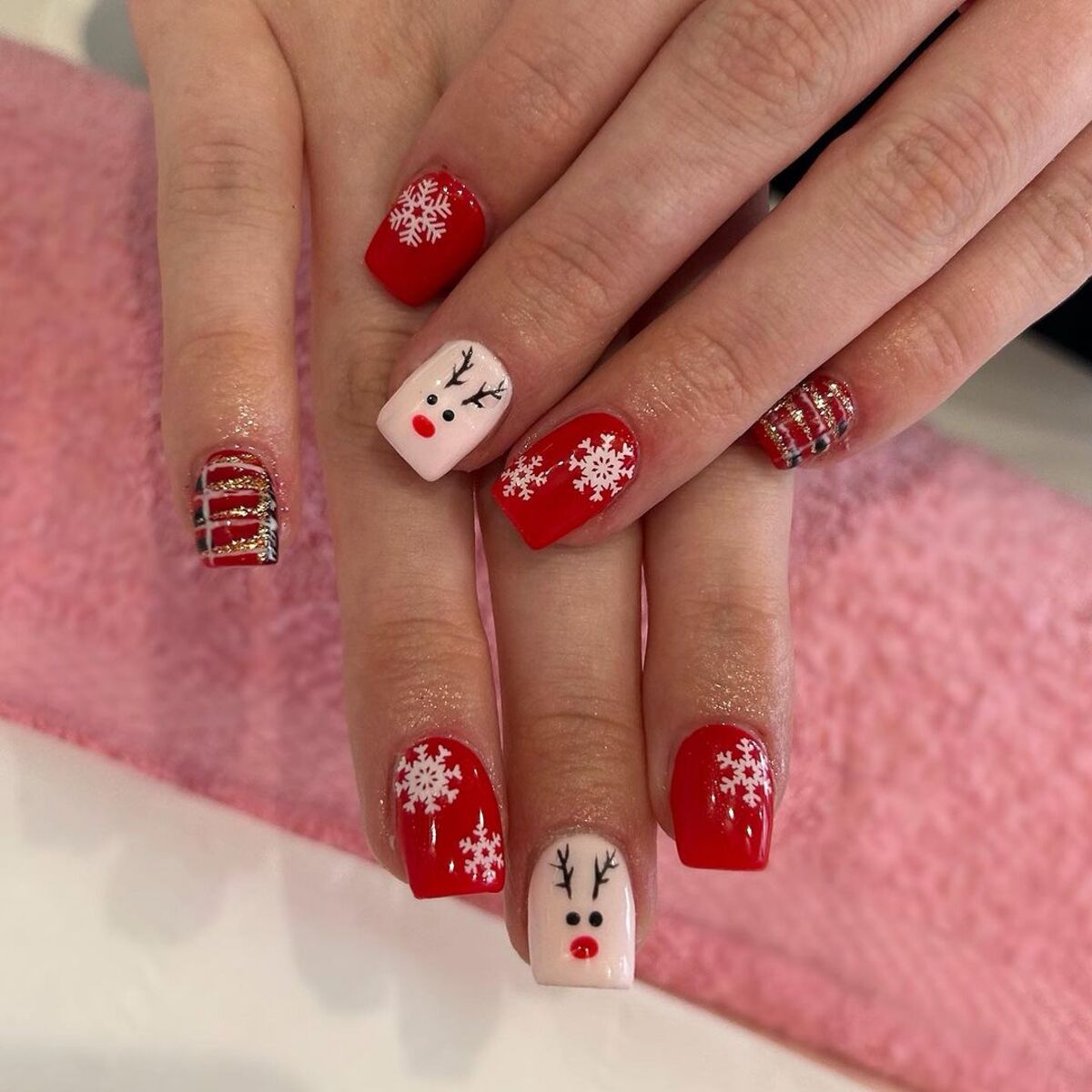 11. Classic Red and White Reindeer Nails with Plaid Accent