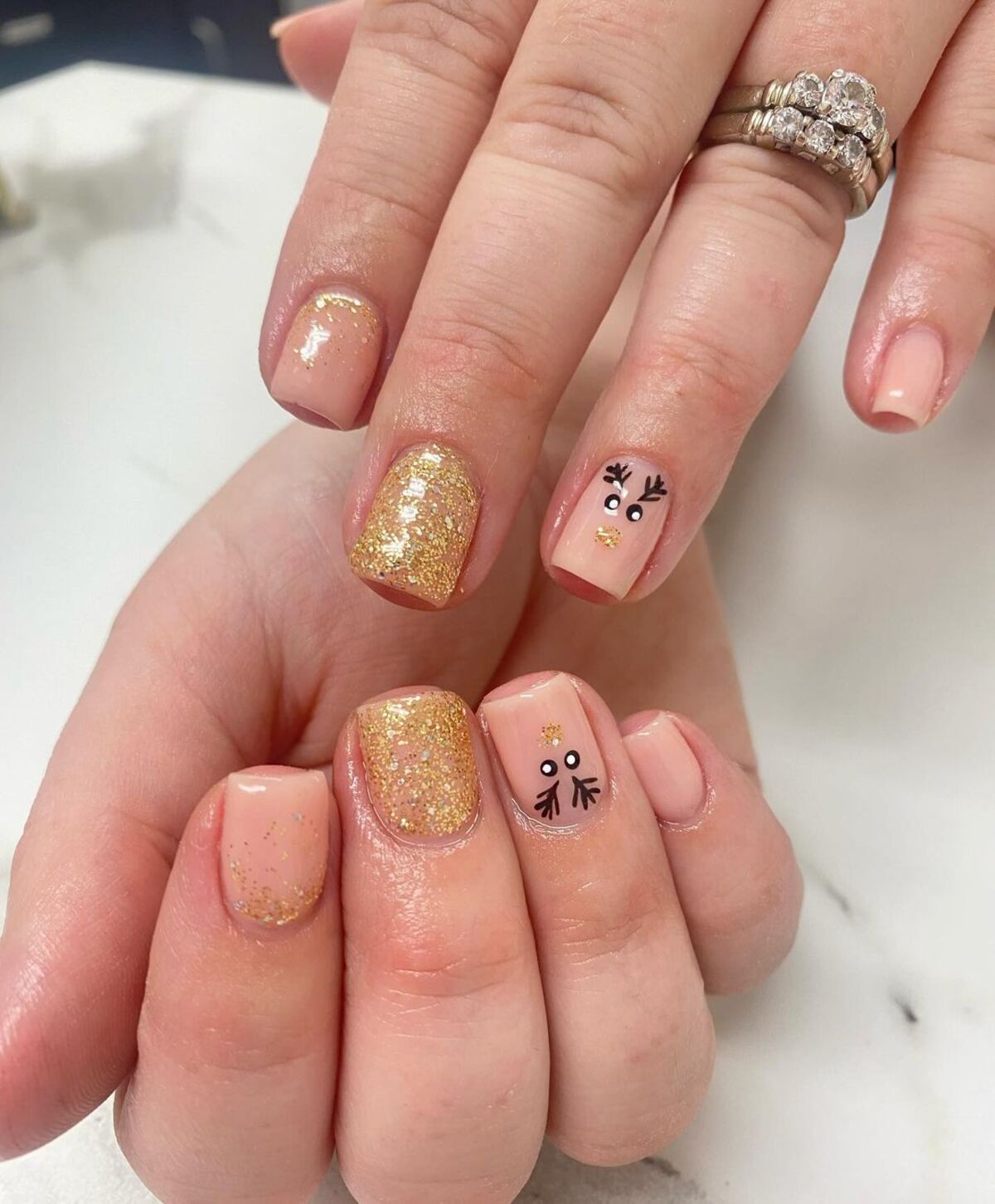 9. Gold Glitter and Reindeer Christmas Nails