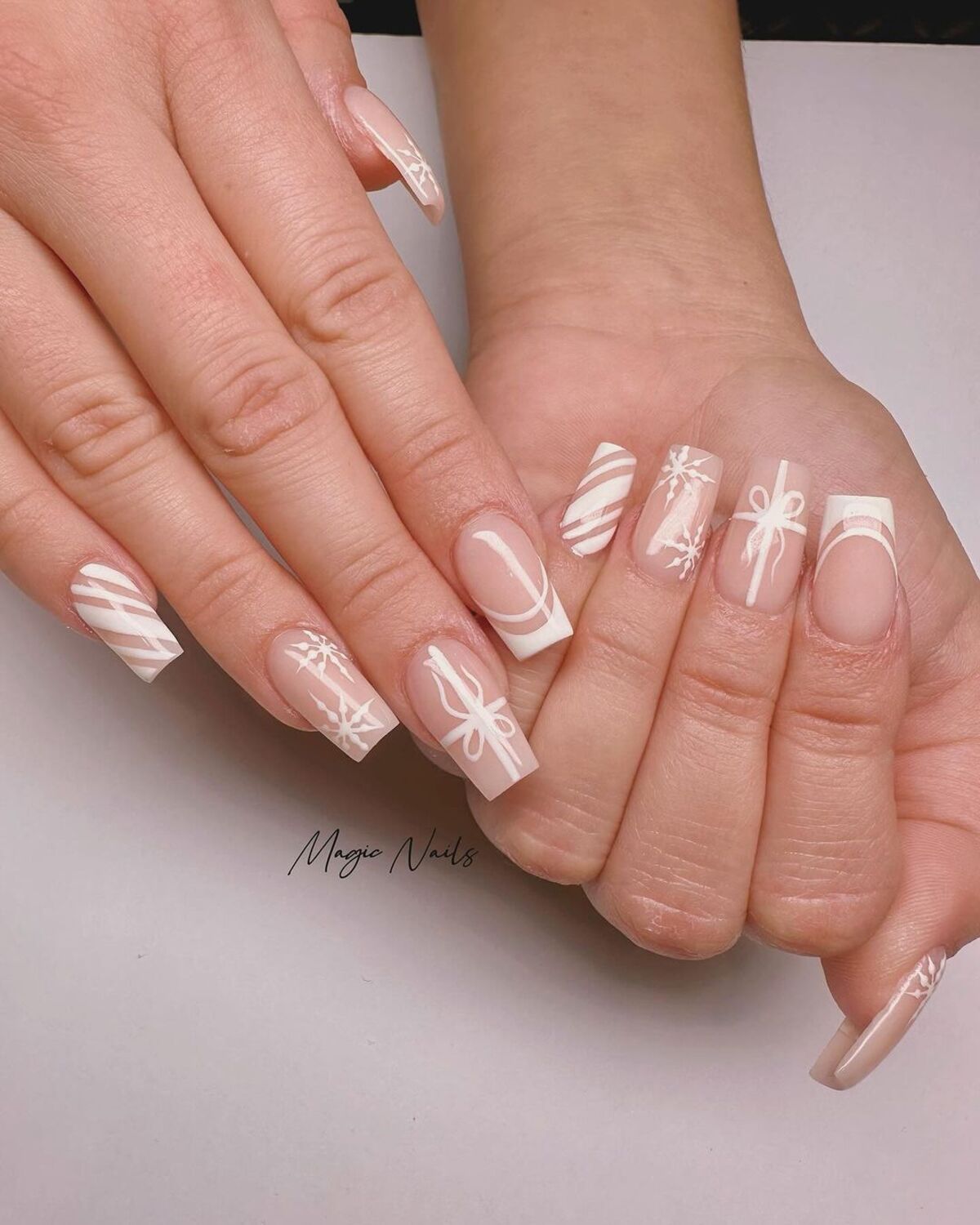 27. White Holiday Presents and Snowflakes on Nude Nails