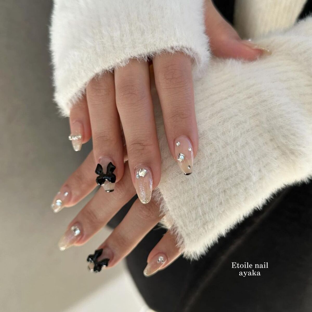 22. Crystal-Studded Nude Nails with Black Bows