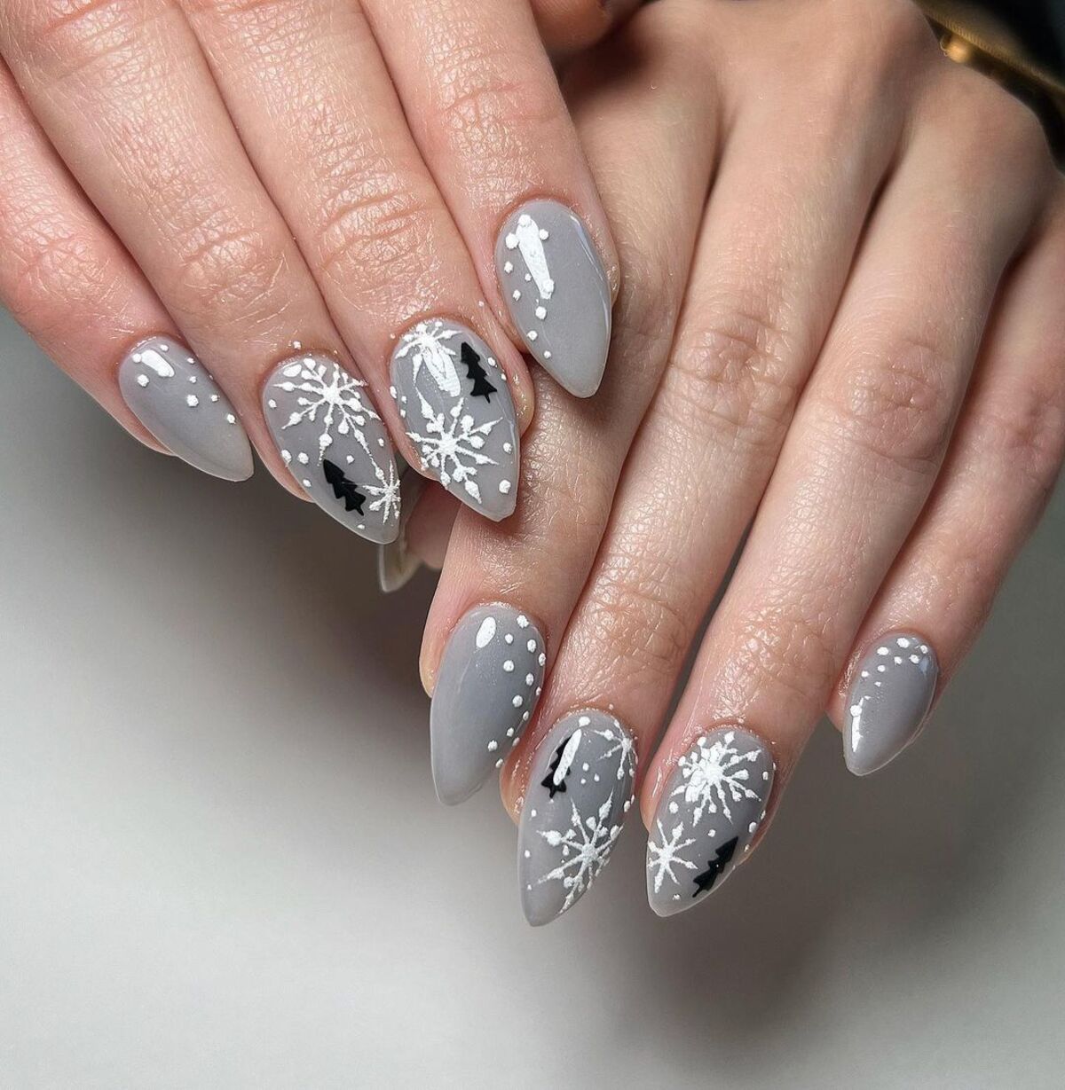 16. Cozy Grey Nails with Snowflakes and Pine Tree Silhouettes