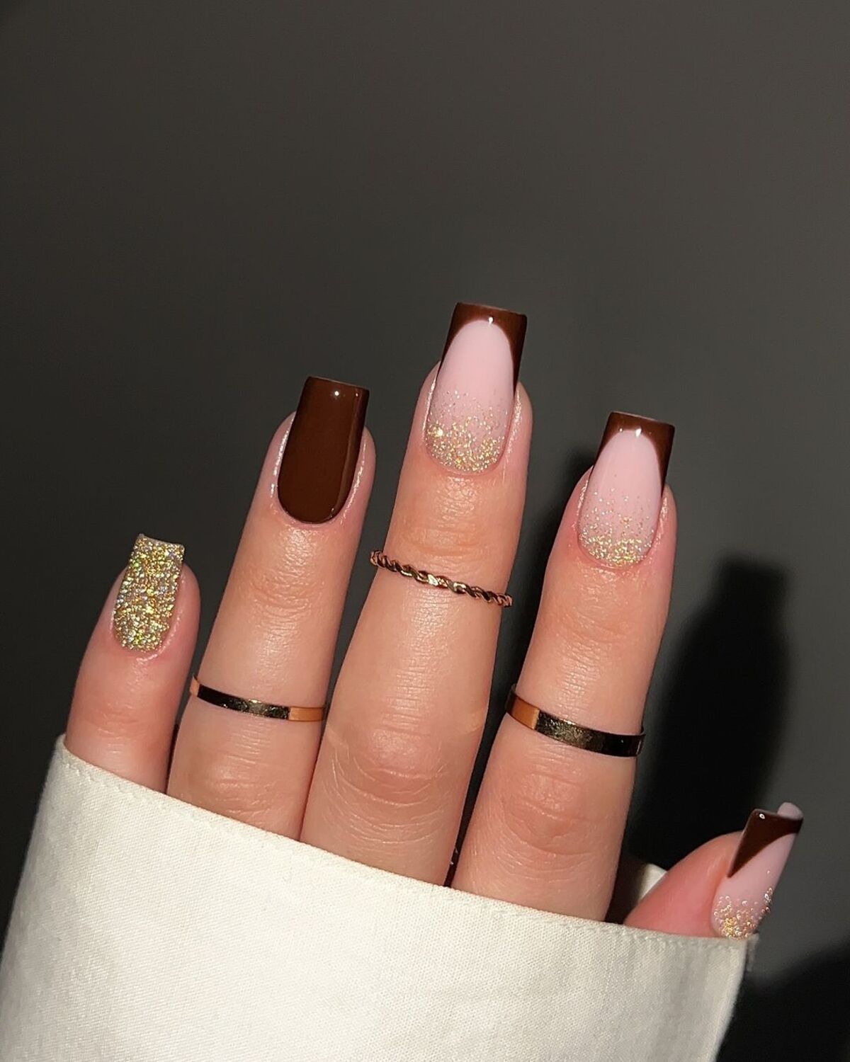 12. Glittery French Tips with Bold Brown Accents