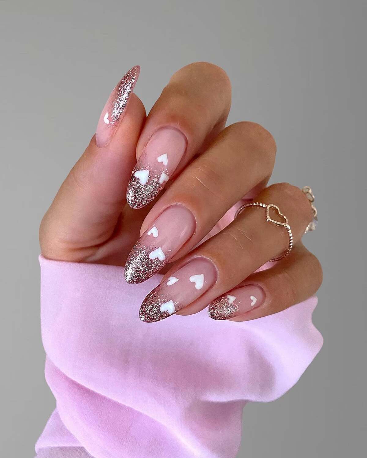 13. Glitter-Tipped Almond Nails with Floating Hearts