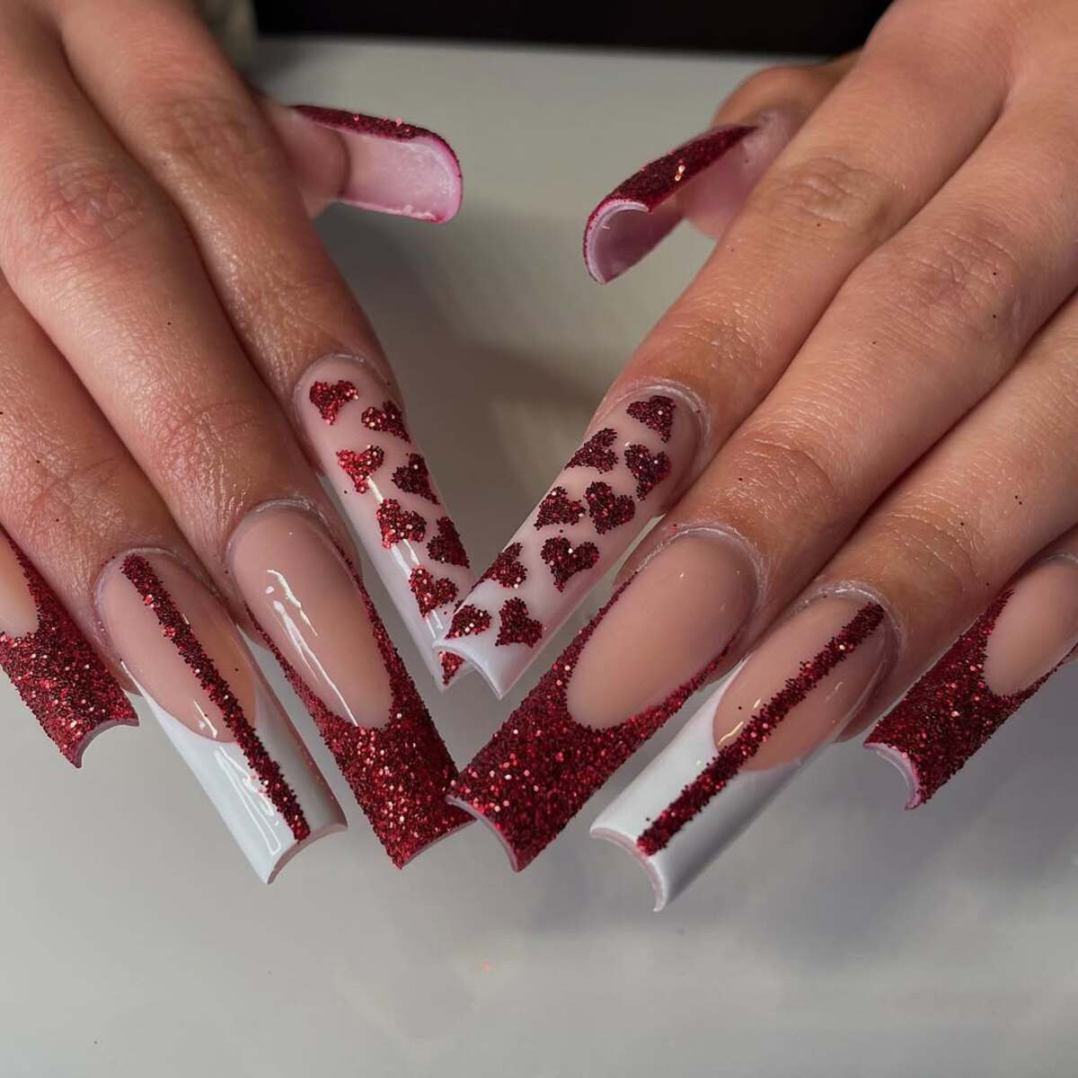 30. Ruby Red Glitter French Tips with Heart Embellishments