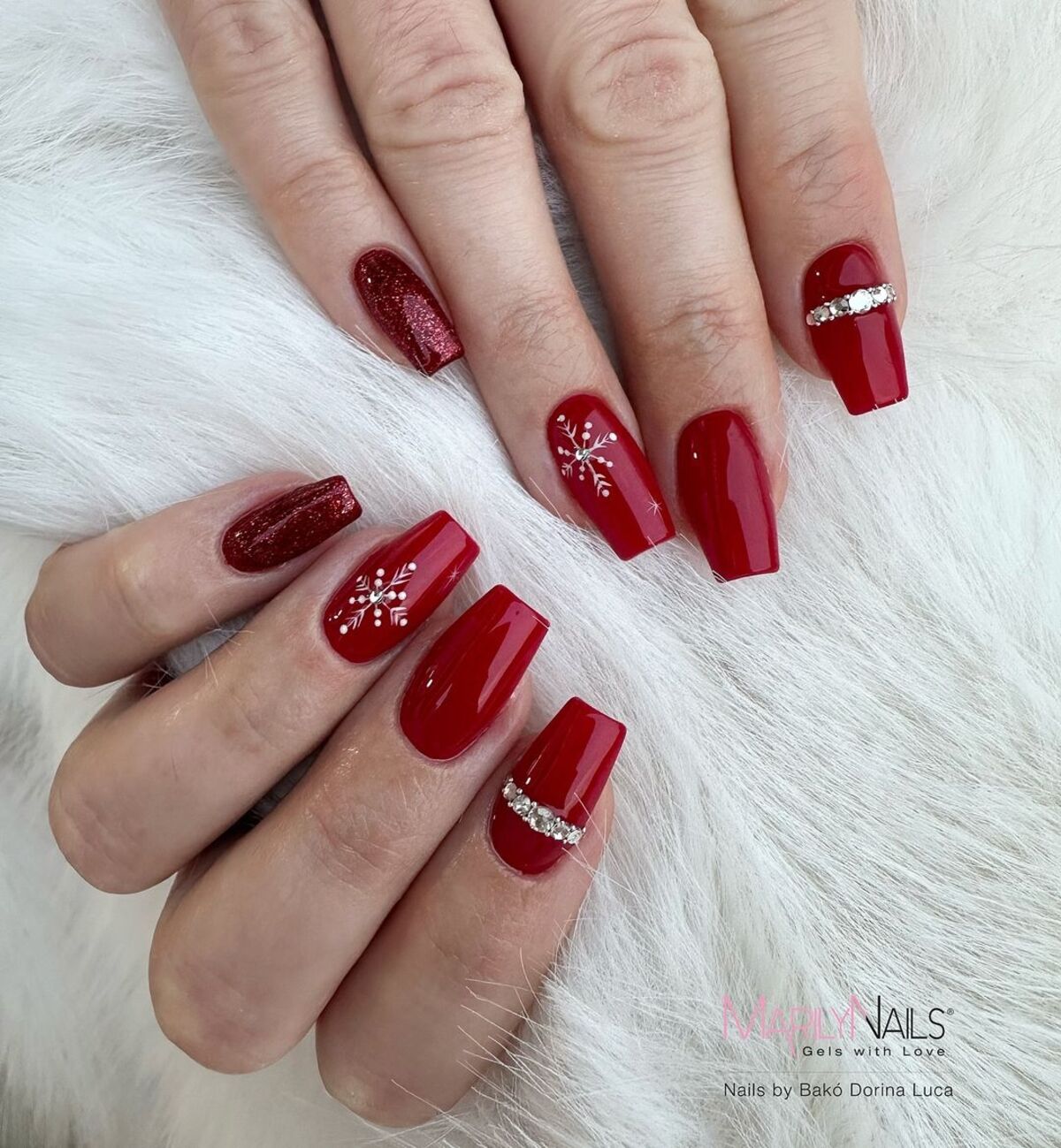 21. Festive Red Nails with Glitter and Snowflakes