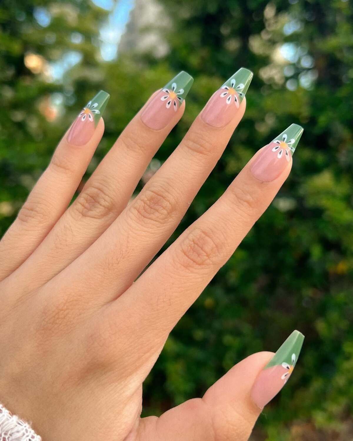 3. Earthy Green French Tips with Minimalist Flowers